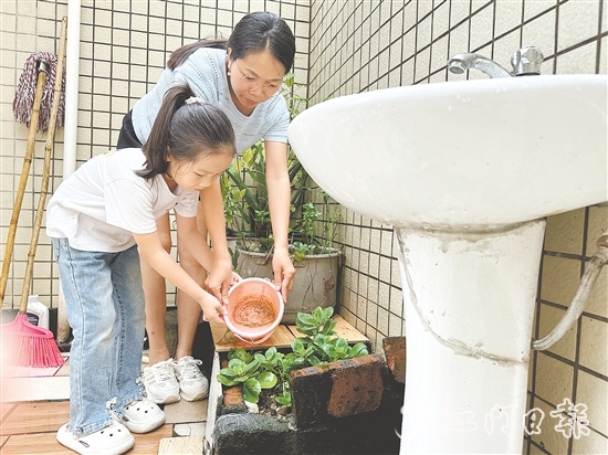 學(xué)生和家長一起清理家中積水。