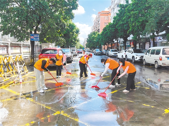 廣東江門中醫(yī)藥職業(yè)學(xué)院大學(xué)生志愿者合力清掃街道積水。