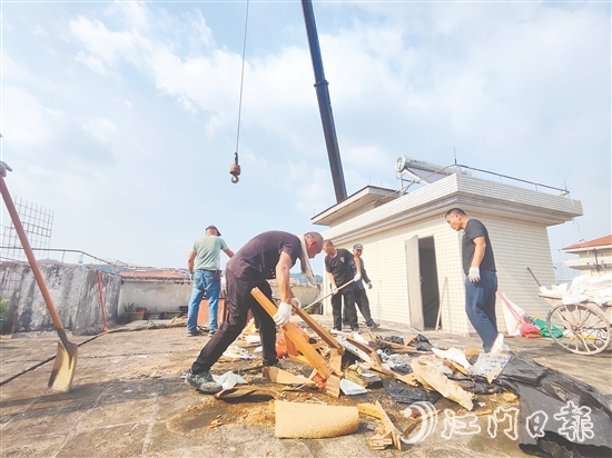 志愿者上門(mén)清理居民樓天臺(tái)的垃圾。