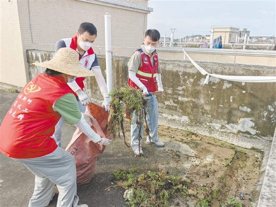 廣大黨員干部當(dāng)先鋒，圖為鶴山市桃源鎮(zhèn)黨員干部正在清理天臺(tái)垃圾。