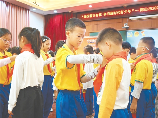 活動(dòng)中，老隊(duì)員熟練地為新隊(duì)員系上紅領(lǐng)巾。