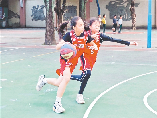 平山小學(xué)女子籃球隊隊員在訓(xùn)練中身姿矯健，運球技巧純熟。