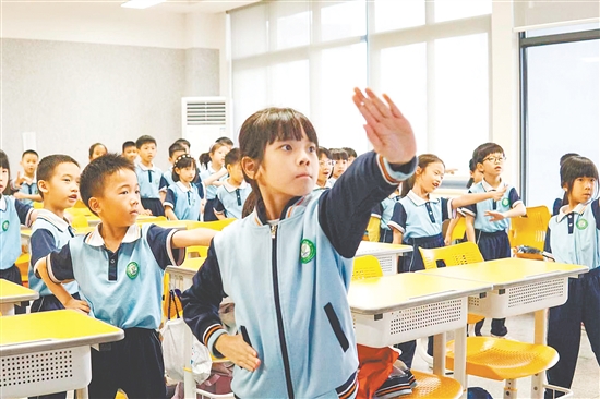 在課桌之間的有限空間中，學(xué)生們跟隨音樂節(jié)奏舒展身體，每一個動作都充滿力量。