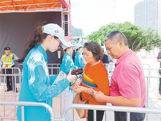 志愿者在場館外為觀眾檢票。