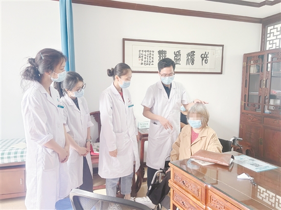 黃任鋒（右二）在中醫(yī)經(jīng)典科門診開(kāi)展教學(xué)。