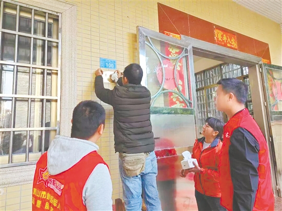 服務(wù)站工作人員細(xì)心地將“光榮之家”牌匾安裝到位。