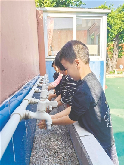 崖門鎮(zhèn)田邊村幼兒園的孩子們打開洗手池新安裝的節(jié)水型水龍頭，感受那潺潺流出的清澈好水。