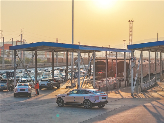 11月29日，在重慶果園港國家物流樞紐鐵路貨運(yùn)魚嘴站商品車物流基地，“重慶造”新能源汽車排隊(duì)駛?cè)搿坝遘嚒睂Ａ?。新華社發(fā)