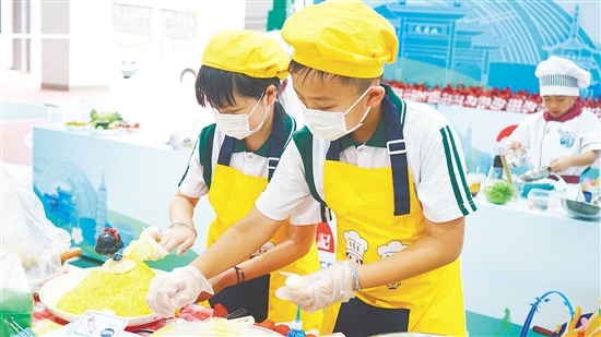 學(xué)生在烹飪比賽中展現(xiàn)勞動(dòng)技能。