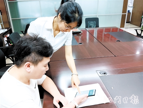 工作人員在指導(dǎo)市民線上交存住宅專項(xiàng)維修資金。陸沿任