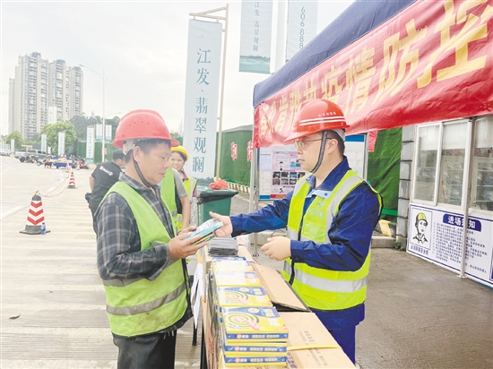 工地施工人員排隊(duì)領(lǐng)取防蚊用品。
