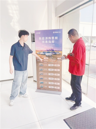 銷售人員向市民介紹優(yōu)惠政策。